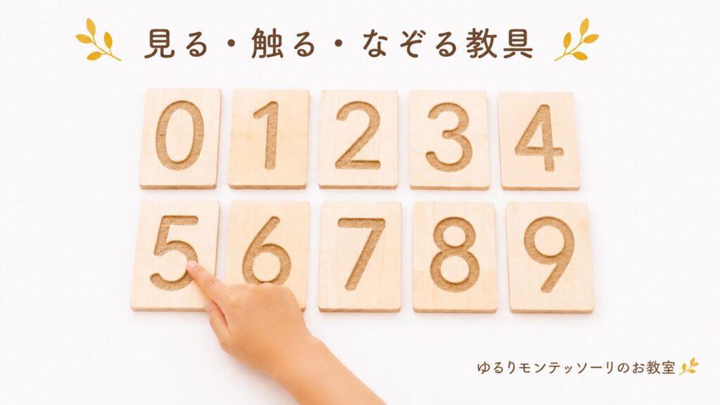 砂数字を指でなぞる子どもの手
